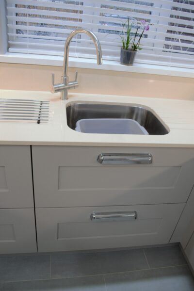 Sleek white quartz worktop harmonizes with an integrated sink in the modern classic kitchen