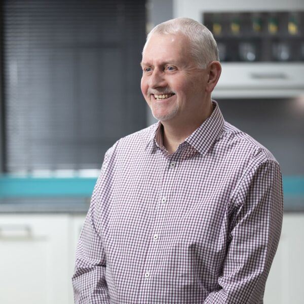 Kitchen Showrooms Operations Director, Neil, wearing a gingham shirt smiling