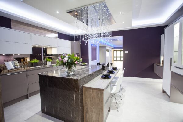 Modern Kitchen with Feature Cluster Pendant Light, Dark Marble Countertop on Island, Two-Toned Cabinetry in Matte Dark Grey and Light Grey, and Integrated Silestone Sink