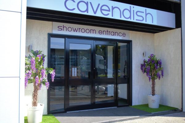 Entrance to Cavendish Kitchens Benton showroom, adorned with plants on either side of the entrance doors