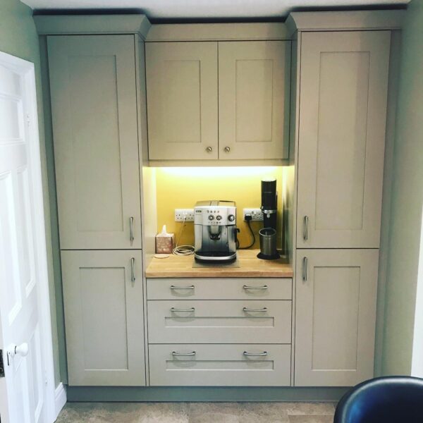 Mint Shaker kitchen cabinets housing an illuminated coffee area with wood worktop