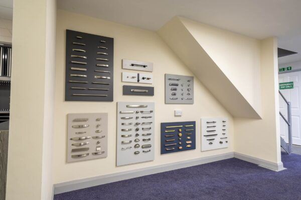 array of fixtures and handle choices displayed on the wall at the Cavendish Kitchens showroom, showcasing various styles available for kitchen cabinet doors