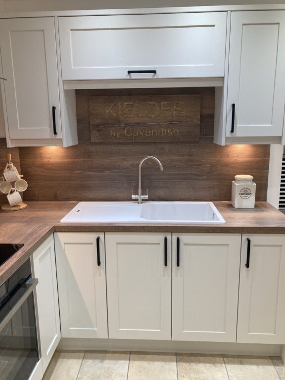 Timeless White Shaker Kitchen with Black Fixtures, Wood Worktops, and Splashback by Cavendish Kitchens